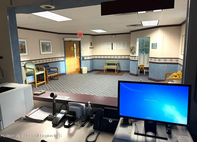 a room with stainless steel appliances dining table wooden floor and a view of kitchen