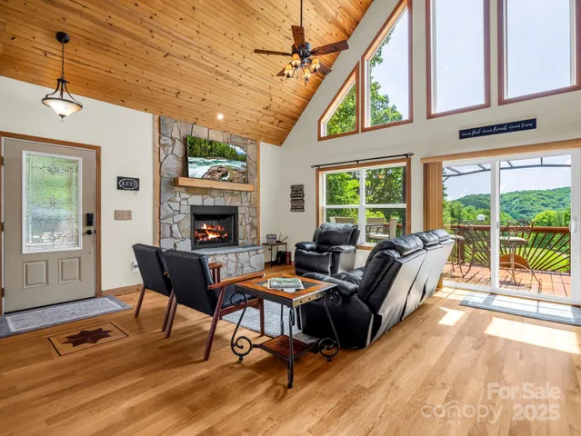 a living room with furniture a fireplace and a floor to ceiling window