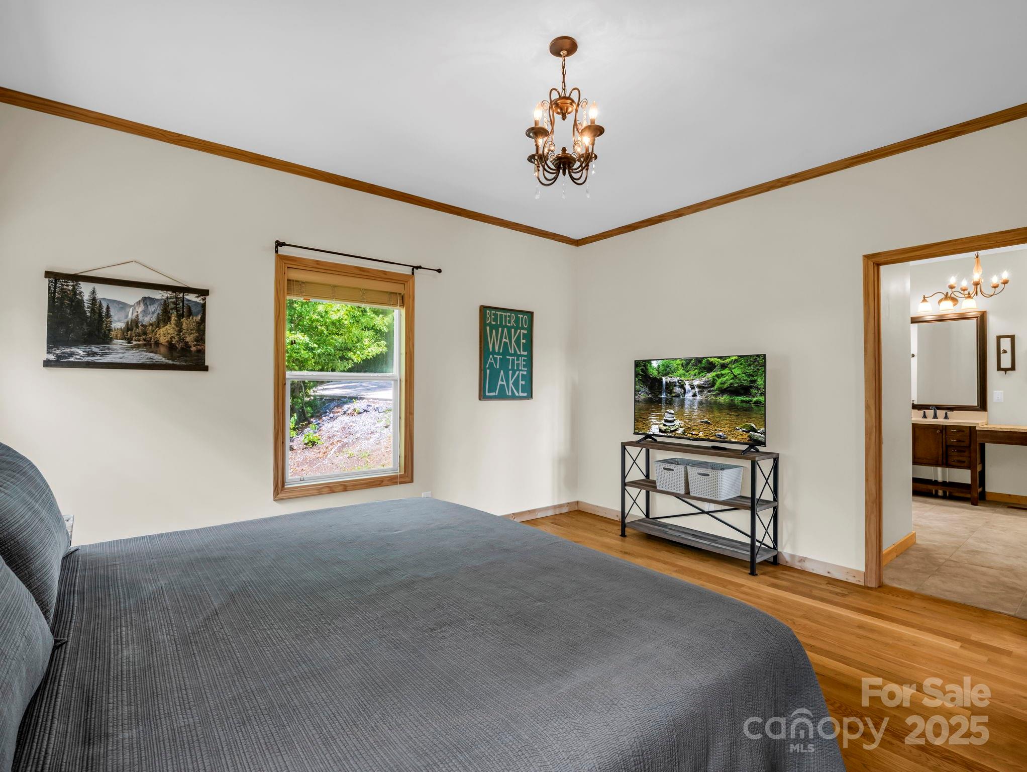 188 Fern Loop Lake Lure, NC 28746 - Photo 23 of 48 a bedroom with a bed and a chandelier