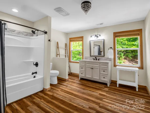 a bathroom with a double vanity sink toilet mirror and bathtub