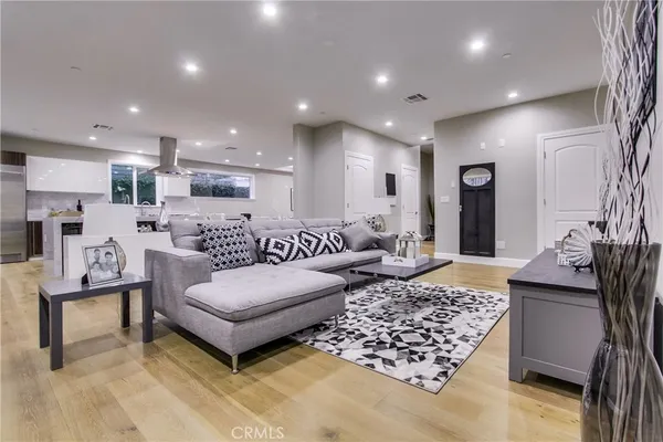 a living room with furniture and a wooden floor