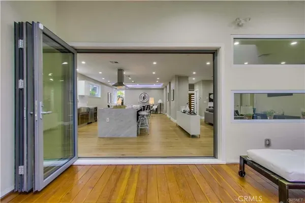 a living room with kitchen view and wooden floor