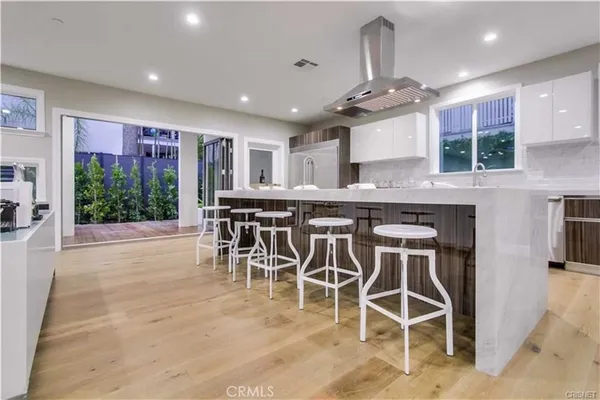 a kitchen with stainless steel appliances granite countertop table chairs sink and cabinets