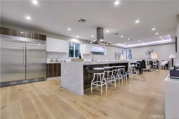 a kitchen with stainless steel appliances kitchen island granite countertop a table and chairs in it