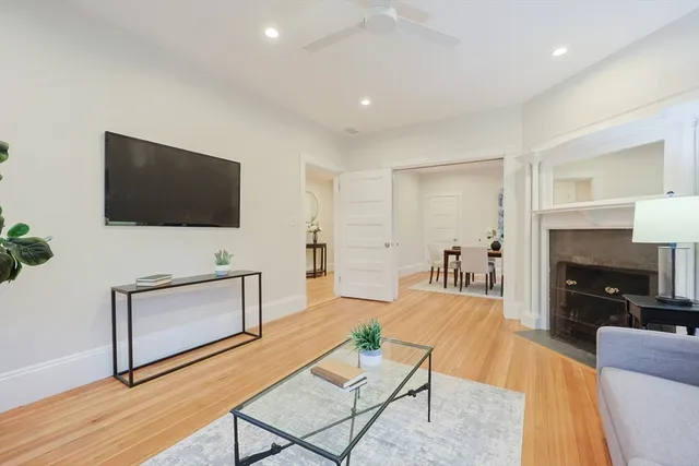 a living room with furniture a flat screen tv and a fireplace
