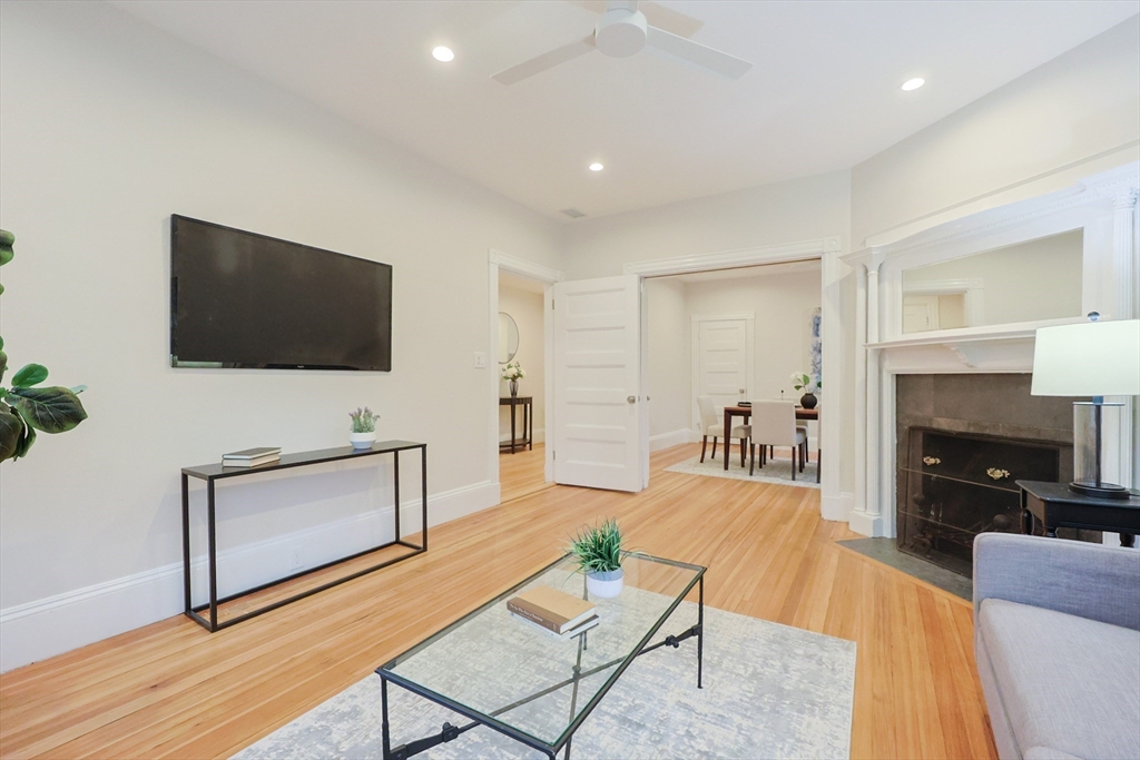 28 Inman Street, Unit 4 Cambridge, MA 02139 - Photo 4 of 32 a living room with furniture a flat screen tv and a fireplace