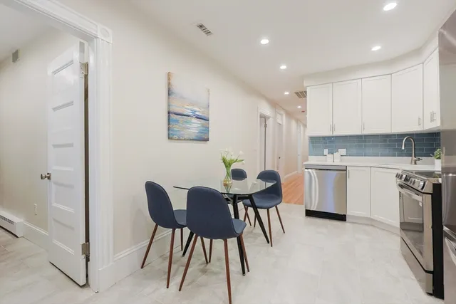 a kitchen with a table chairs sink and cabinets