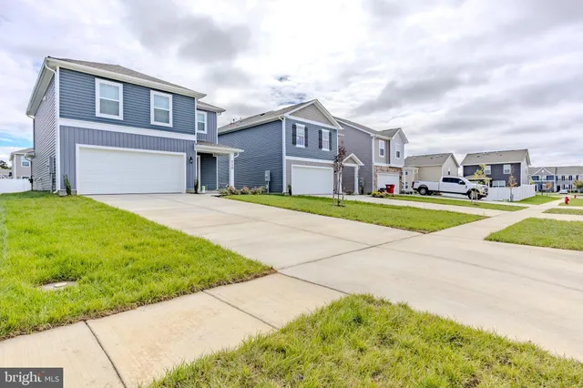 a view of a big house with a big yard and large trees