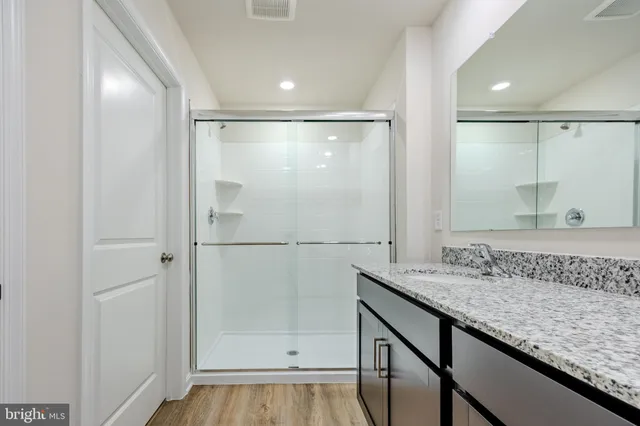 a bathroom with a granite countertop sink and a mirror
