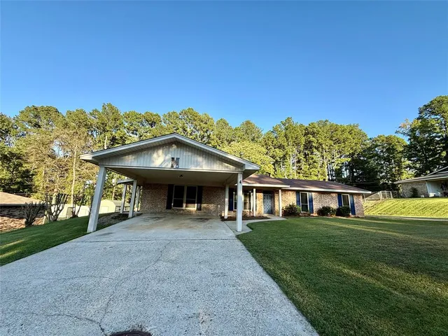 a view of a house with big yard and large trees