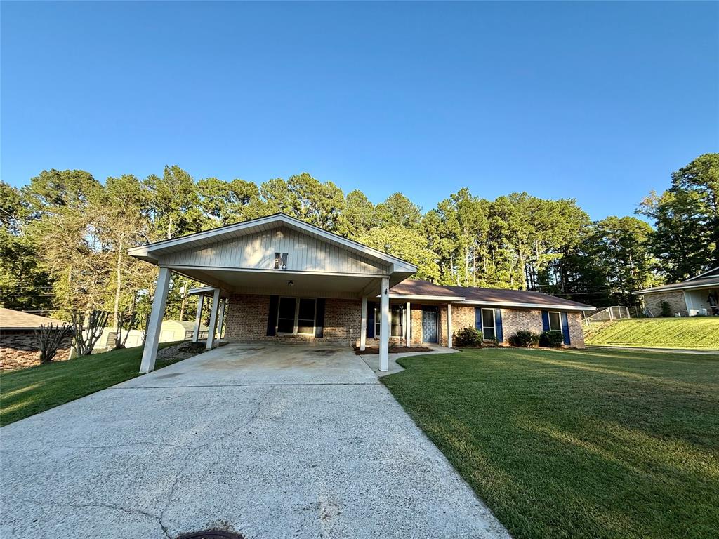 a view of a house with big yard and large trees