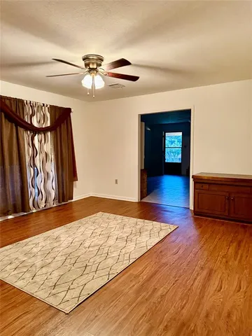a view of an empty room and window with wooden floor
