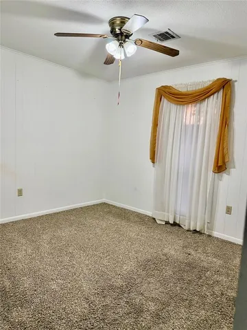 a view of a room with a ceiling fan and a window