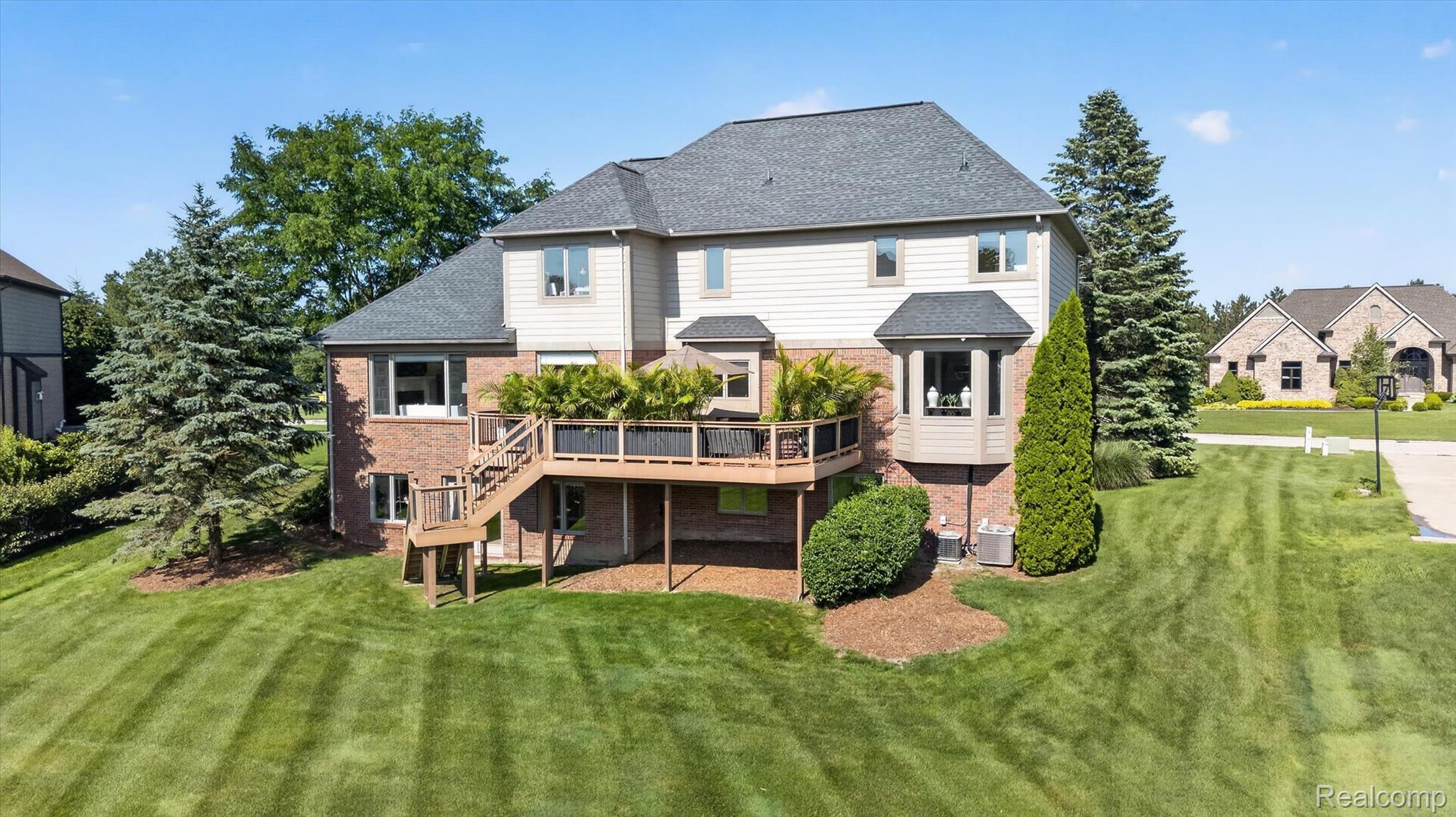 3804 Elk Drive Rochester, MI 48306 - Photo 61 of 75 Rear exterior featuring a multi-level wood deck with stairs, brick and siding facade, bay window, and a spacious green lawn