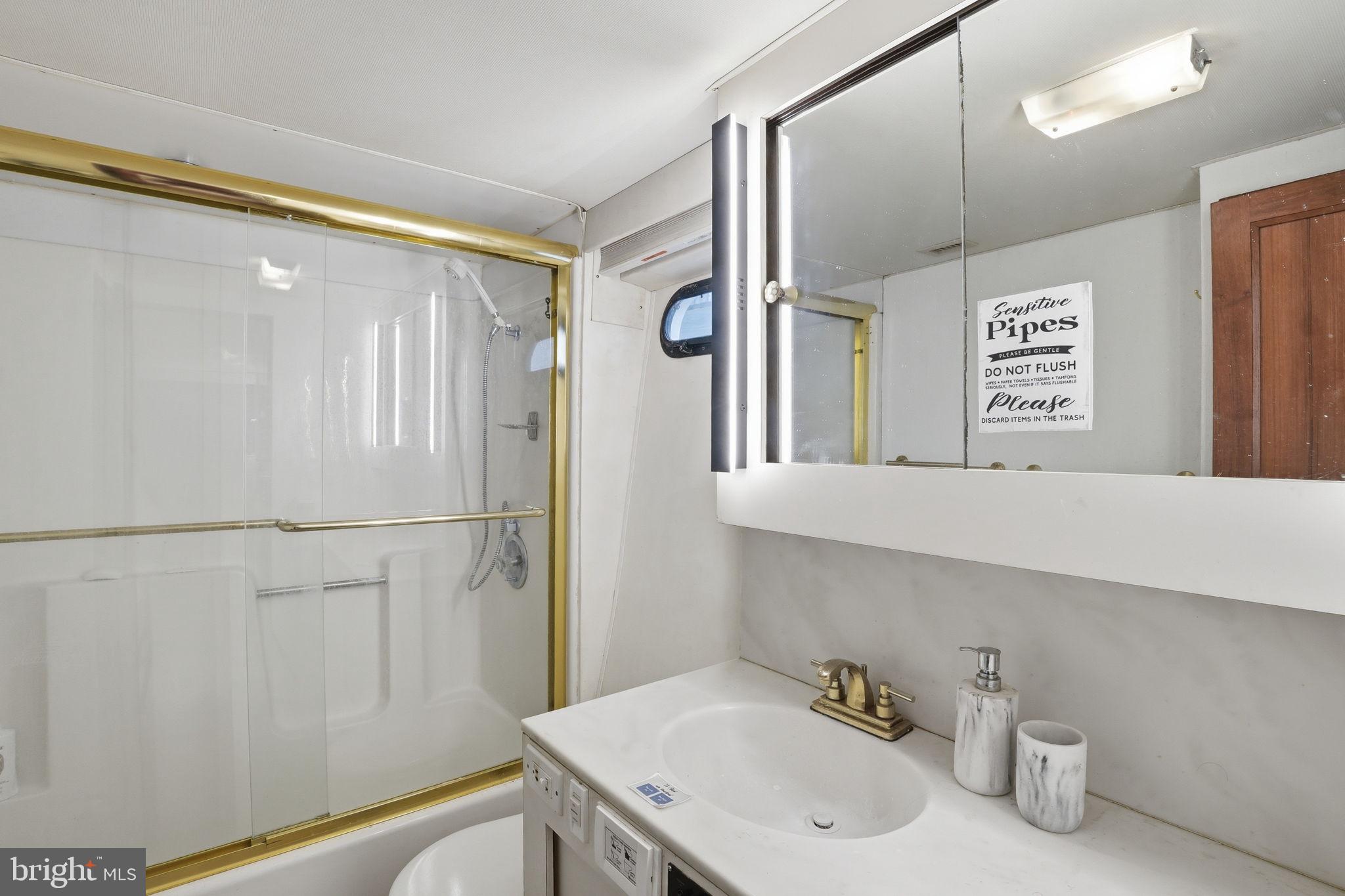 650 Wharf Street Southwest, Unit X48 Washington, DC 20024 - Photo 21 of 42 a bathroom with a sink a mirror and a shower