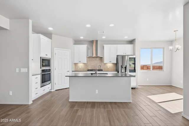 an empty room with wooden floor and natural light