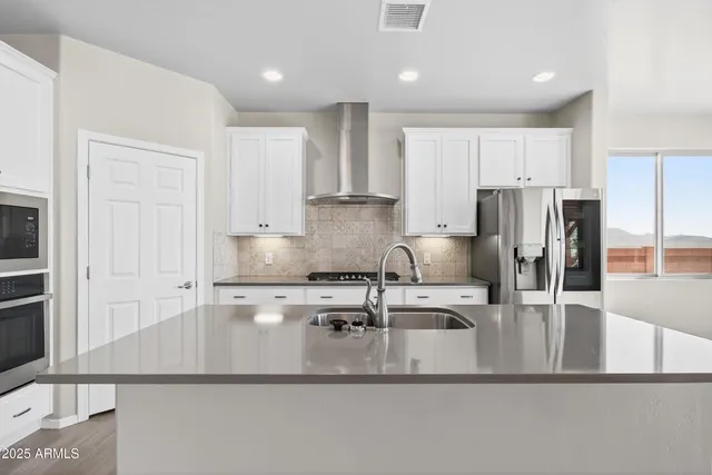 a kitchen with stainless steel appliances a refrigerator and a stove top oven