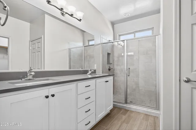a view of an empty room with chandelier fan