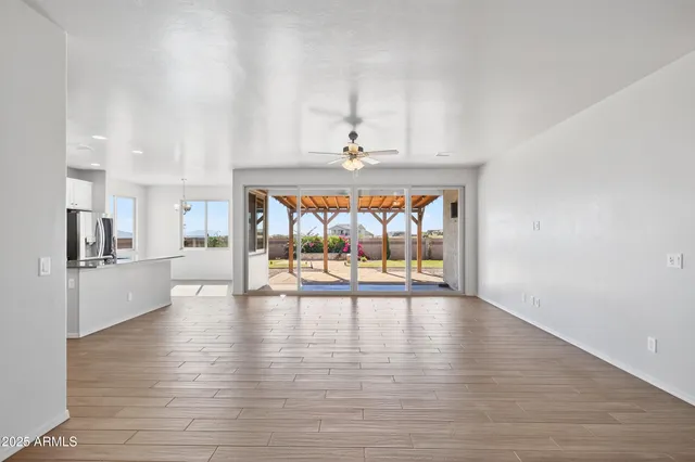 a view of a chandelier in big room and hallway with wooden floor