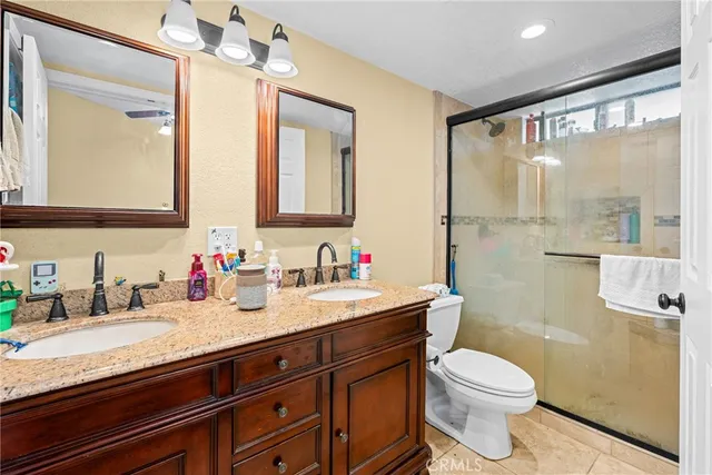a bathroom with a granite countertop sink a toilet and a mirror
