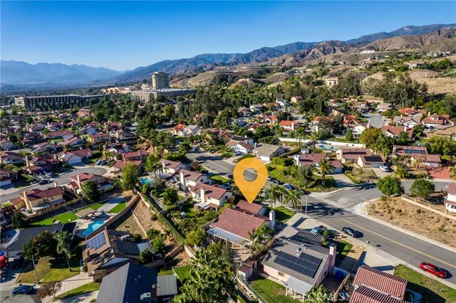an aerial view of residential houses with outdoor space and trees