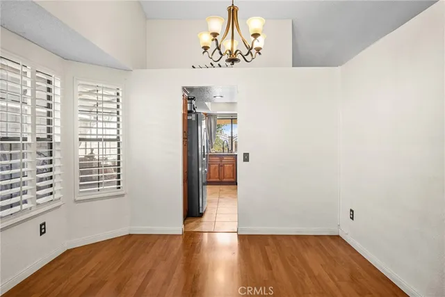 a view of a big room with wooden floor and windows