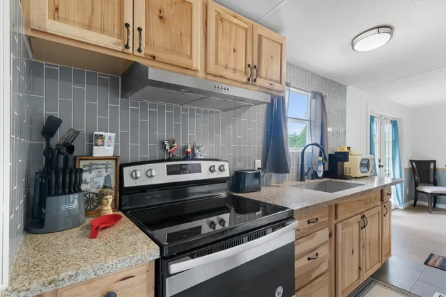 a kitchen with stainless steel appliances granite countertop a sink stove and cabinets