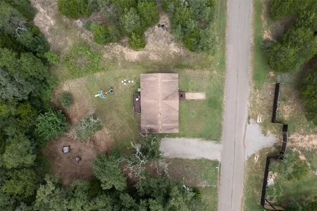 an aerial view of a house with a yard and trees all around