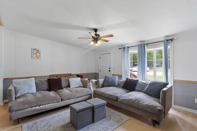 a living room with furniture and a ceiling fan