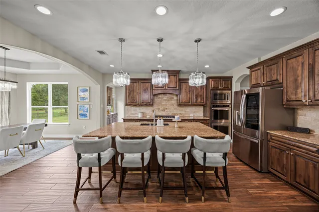 a kitchen with stainless steel appliances granite countertop a refrigerator and a stove