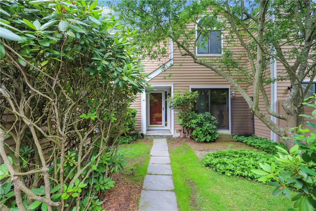 a front view of a house with a yard and potted plants