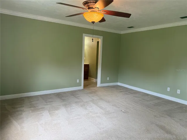an empty room with a fan and window