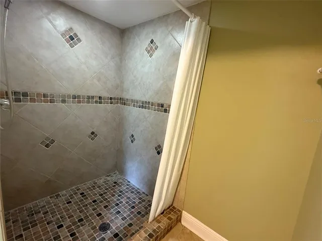 a bathroom with a granite countertop shower and a sink