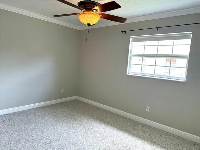 an empty room with a fan and a fan