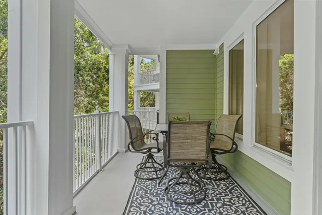 a balcony with wooden floor outdoor seating and yard in back