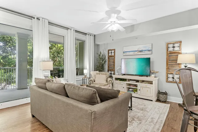 a living room with furniture a flat screen tv and a large window