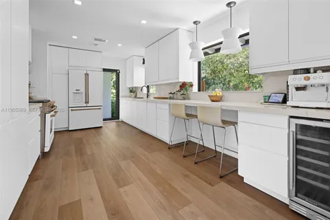 a kitchen with white cabinets and appliances