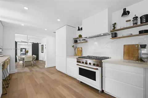 a kitchen with stainless steel appliances white cabinets and wooden floor