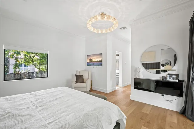 a bedroom with a large bed and a chandelier