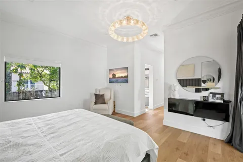 a bedroom with a large bed and a chandelier