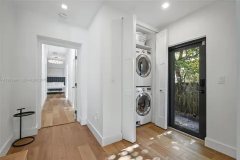 a view of a hallway with wooden floor and a bathroom