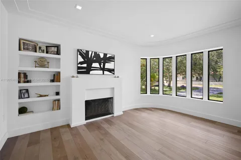 a view of an empty room with a window and fireplace