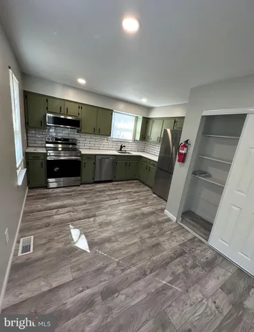 a kitchen with stainless steel appliances wooden cabinets and stove top oven