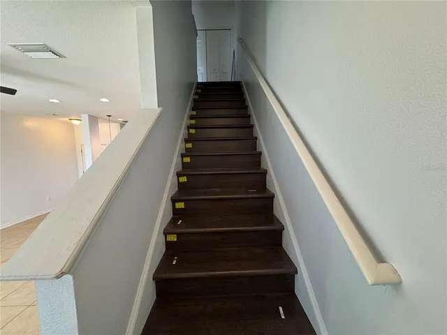 a view of a hallway with wooden floor and chandelier