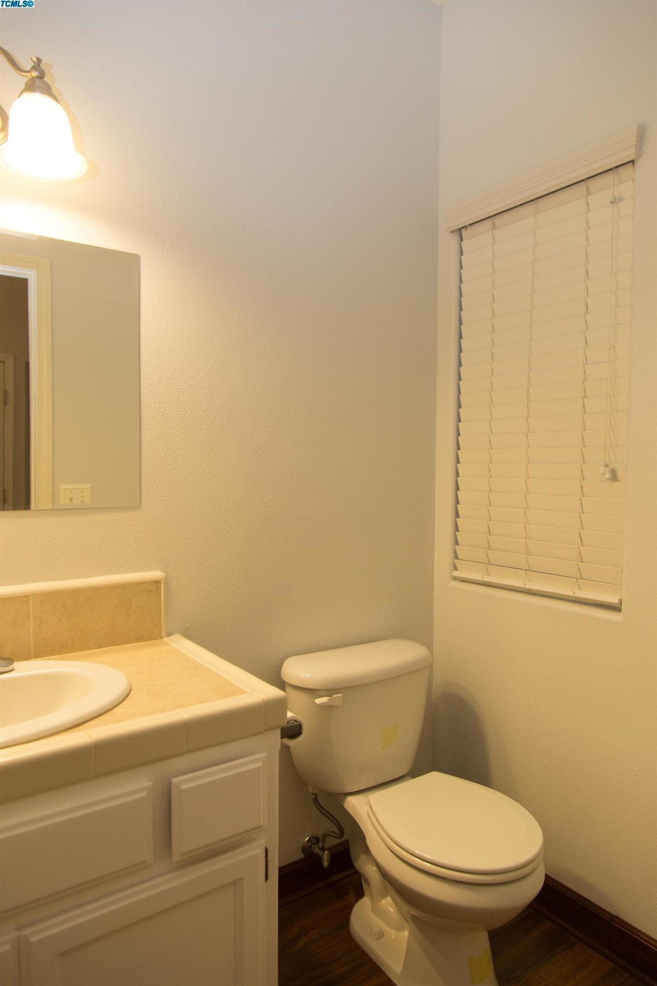 148 South Filbert Road Exeter, CA 93221 - Photo 7 of 23 a bathroom with a toilet and a shower curtain