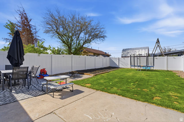 282 West 960 South, Unit C Provo, UT 84601 - Photo 27 of 33 Fenced backyard featuring outdoor dining space, a trampoline, and a patio area
