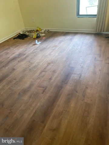 an empty room with wooden floor and a window