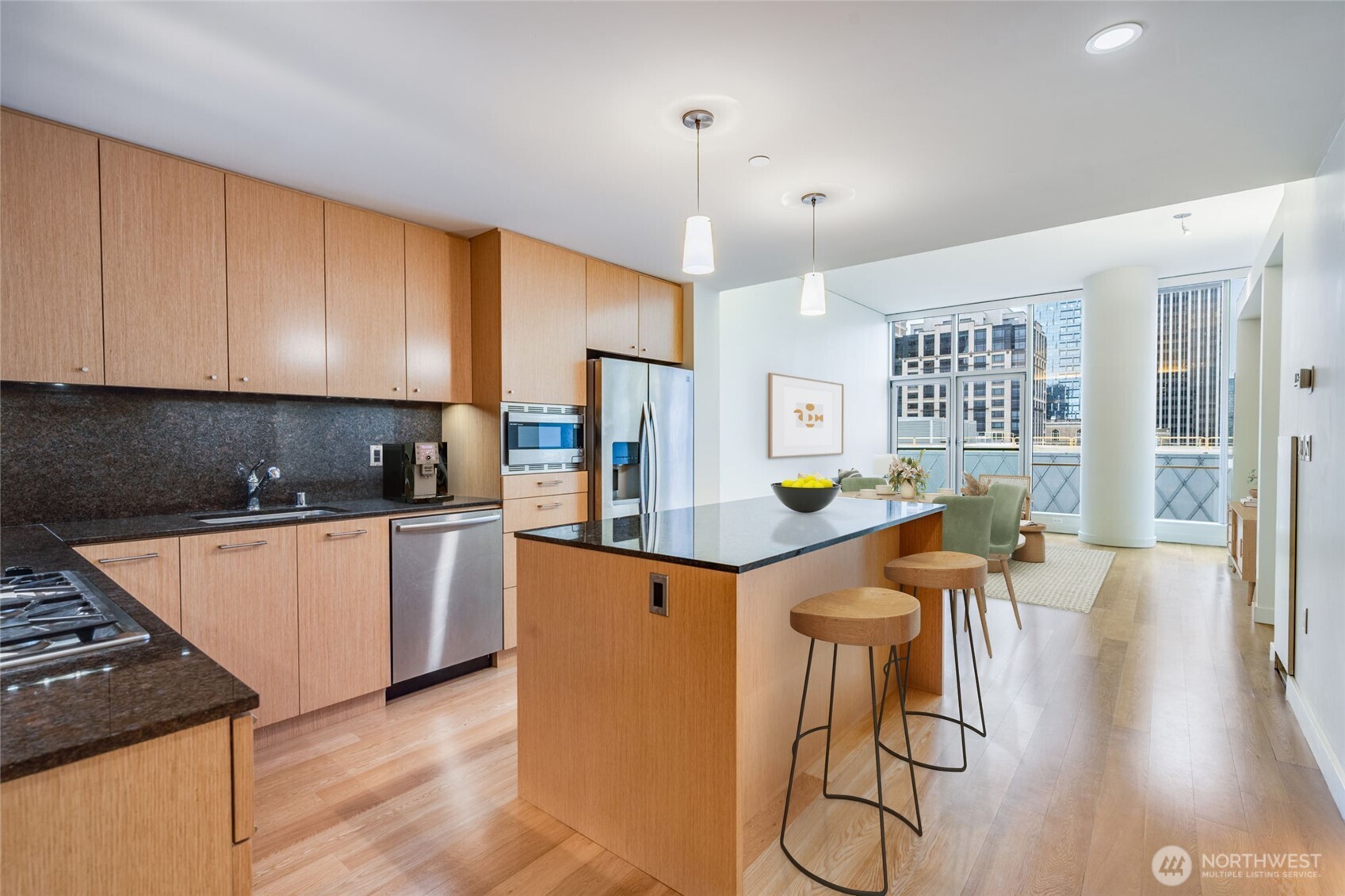 909 5th Avenue, Unit 1203 Seattle, WA 98164 - Photo 13 of 32 a kitchen with granite countertop a table chairs stove and wooden floor