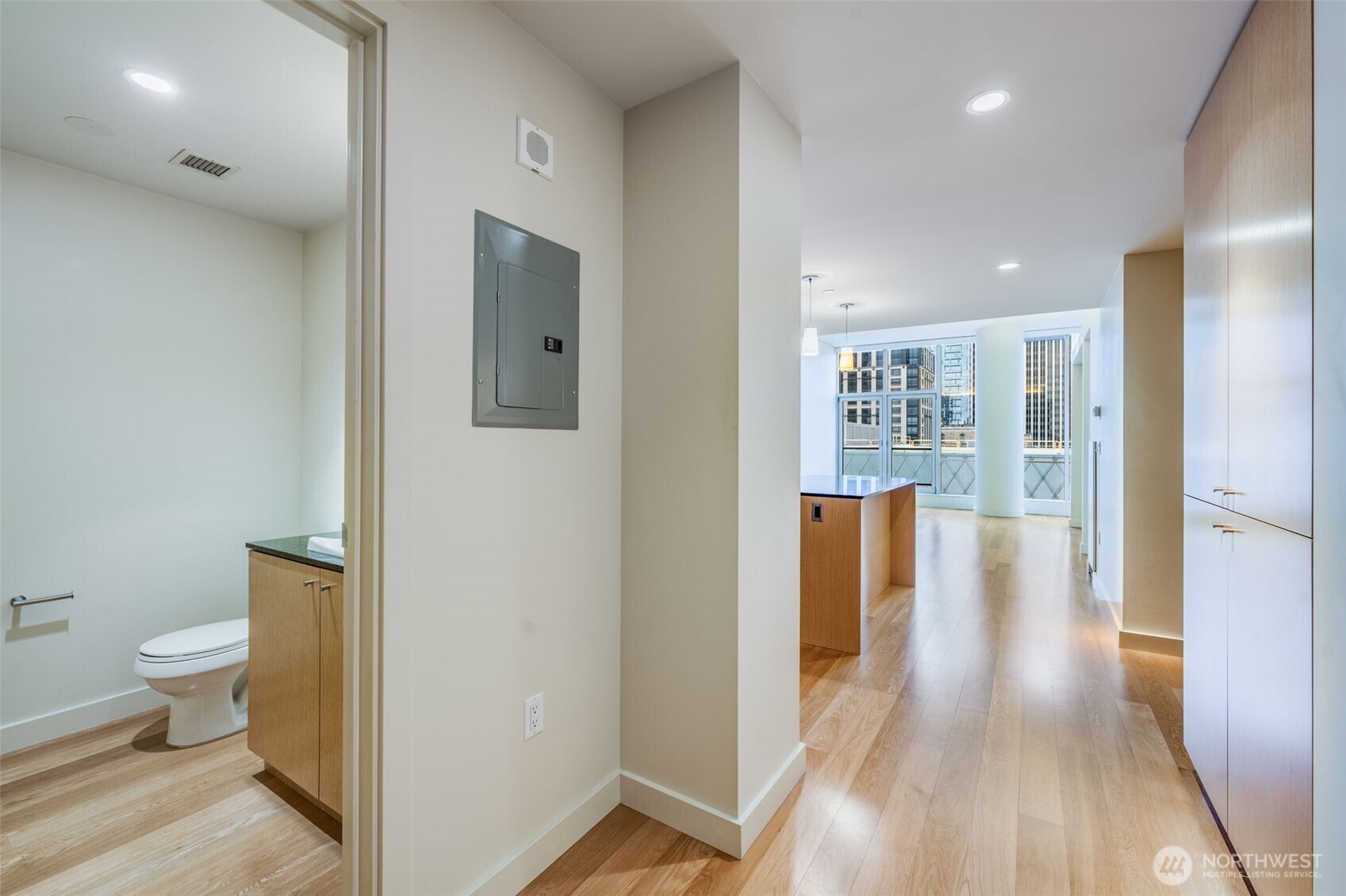 909 5th Avenue, Unit 1203 Seattle, WA 98164 - Photo 18 of 32 a view of a hallway with wooden floor and a bathroom