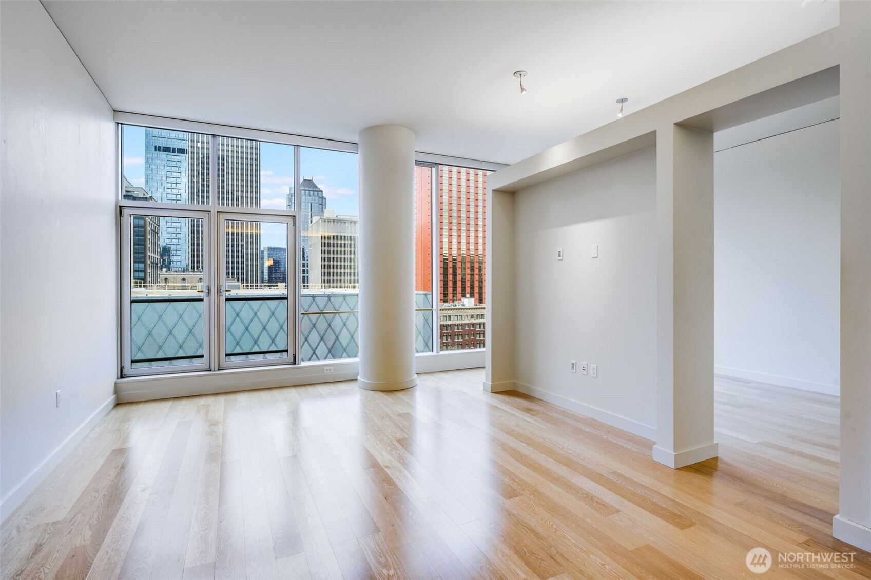 909 5th Avenue, Unit 1203 Seattle, WA 98164 - Photo 2 of 32 a view of an empty room with wooden floor and a window